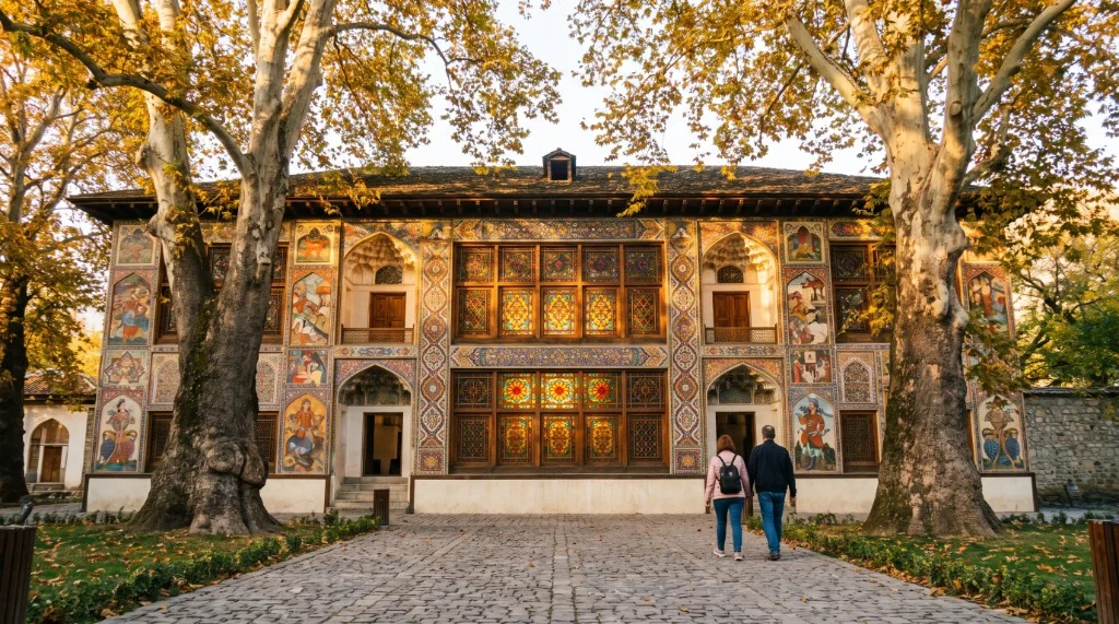 Payızda Şəki Xan Sarayının rəngli şəbəkə pəncərələri və qızılı yarpaqlı çinar ağacları